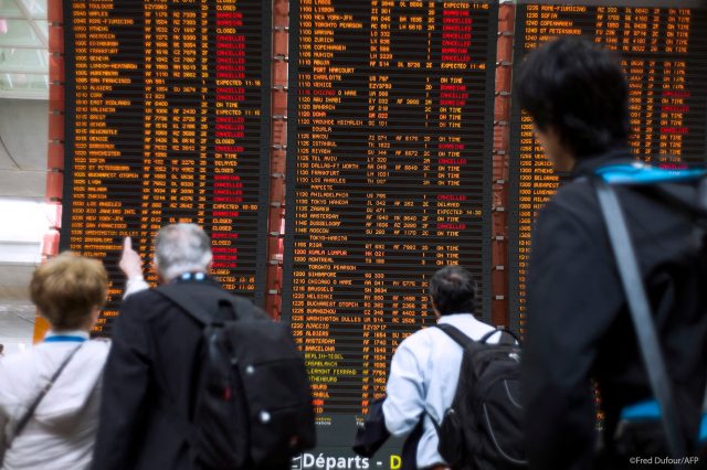 Călătorii privesc tabela cu Plecări cu multe zboruri anulate, la aeroportul internațional Roissy Charles de Gaulle lângă Paris sursa PE